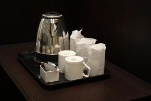 a tray with a tea pot and cups on a table at Sulu Residency in Cochin