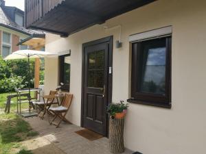 a house with a black door and a table with chairs at Ruhe am Wald - zentral und Wörthersee in Klagenfurt