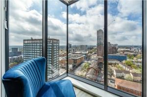 a room with a blue chair and a large window at the bank in Birmingham