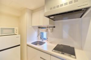 a small kitchen with a sink and a microwave at TORA HOTEL Sensoji 寅ホテル 浅草寺 in Tokyo