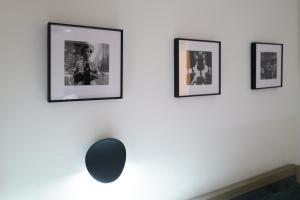 a row of framed pictures on a white wall at TORA HOTEL Sensoji 寅ホテル 浅草寺 in Tokyo