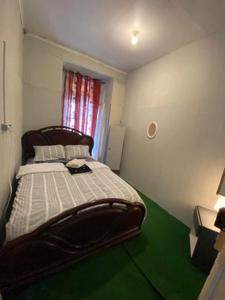 um quarto com uma cama e um piso verde em Lisbon Bangla em Lisboa