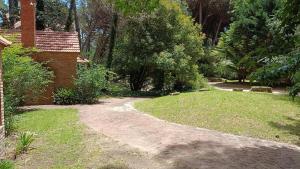 un camino de tierra en un patio al lado de una casa en Casa Algarrobo Carilo en Cariló