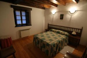 a bedroom with a bed and a table and a window at Alojamiento Rural Casa La Mata. in Cuñaba