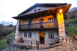 Cette petite maison en pierre dispose d'un balcon sur une colline. dans l'établissement Alojamiento Rural Casa La Mata., à Cuñaba