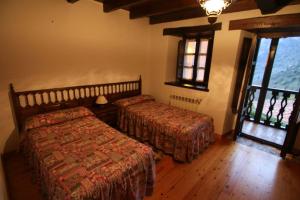 a bedroom with two beds in a room with windows at Alojamiento Rural Casa La Mata. in Cuñaba