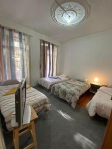 1 dormitorio con 2 camas y TV en una mesa en Lisbon Bangla, en Lisboa