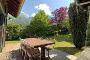a wooden table and chairs on a deck with a view at ⁂ Chalet Alizée · Nature, lac et montagnes ⁂ in Alex