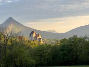 a castle on a hill with mountains in the background at ⁂ Chalet Alizée · Nature, lac et montagnes ⁂ in Alex