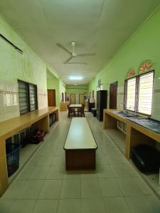een lege kamer met bureaus en tafels in een kamer bij Penginapan Harmoni Inn in Kuala Terengganu