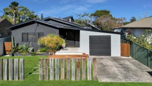 a house with a fence in front of it at Gorgeous Getaway Toowoon Bay in Long Jetty