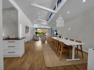 uma cozinha e sala de jantar com uma mesa branca e cadeiras em Gorgeous Getaway Toowoon Bay em Long Jetty