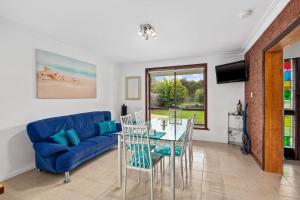 a living room with a blue couch and a table at 27 Seashell Avenue Cape Woolamai VIC 3925 in Cape Woolamai