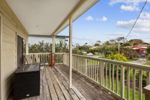 a porch with two chairs on a wooden deck at 27 Seashell Avenue Cape Woolamai VIC 3925 in Cape Woolamai