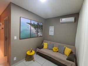 Eco Resort Praia dos Carneiros - Flat 116CM, apartamento completo ao lado da igrejinha في بريا دوس كارنيروس: غرفة معيشة مع أريكة وإطلالة على المحيط