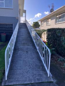 a stairway leading to a house with a white railing at Townhouse on Courtenay in New Plymouth