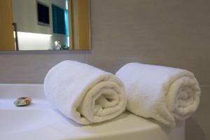 a pair of towels sitting on top of a bathroom sink at SoBlue Hôtel in Antibes