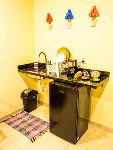 a kitchen with a black counter and a dishwasher at Pousada & Glamping Terra de Aquários in Aiuruoca