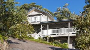 Casa blanca grande con balcón y entrada en Cabane Sur Mer, en Shoal Bay