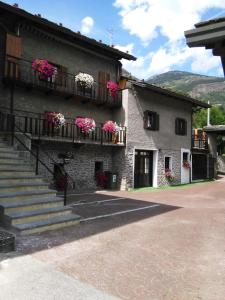 a building with flowers on the balconies and stairs at B&B La Vieille Meison de Pappa in Aosta