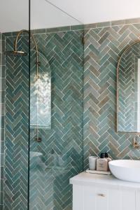 a bathroom with a green tiled wall at The Brooklet in Brooklet