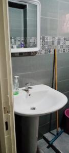 ein Badezimmer mit einem weißen Waschbecken und einem Spiegel in der Unterkunft Qamars'geusts in Al Hoceïma