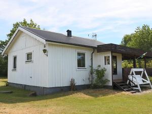 a white house with a porch and a chair at 7 person holiday home in TRÄLÖVSLÄGE-By Traum in TrÃ¤slÃ¶vslÃ¤ge