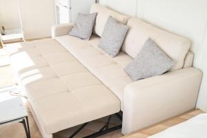 um sofá branco numa sala de estar com duas almofadas em ReTreat佐渡風島 グランピング- Self Check-In Only em Sado