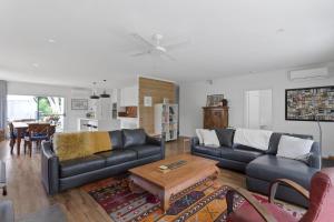 a living room with a couch and a table at Woodland Retreat in Cowes +8 photos