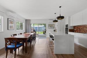 a kitchen and dining room with a table and chairs at Woodland Retreat in Cowes