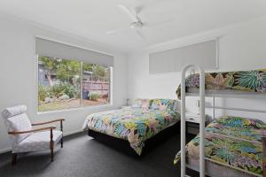 a bedroom with two bunk beds and a chair at Woodland Retreat in Cowes
