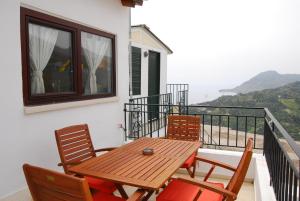 een houten tafel en stoelen op een balkon met uitzicht bij Spitaki in Plakias