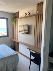 1 dormitorio con escritorio, 1 cama y ventana en Estúdio com Decoração Charmosa e Piscina compart, en Salvador