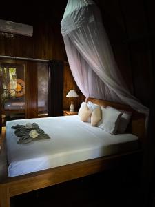 a bedroom with a bed with a canopy at Hakuna Matata Resort Gili Air in Gili Air