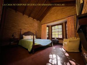 1 dormitorio con 1 cama y 1 silla en una habitación en Casa Algarrobo Carilo en Cariló