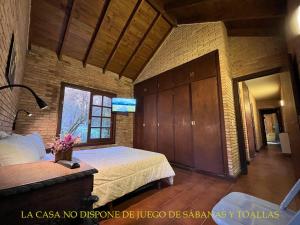 1 dormitorio grande con cama y ventana en Casa Algarrobo Carilo en Cariló