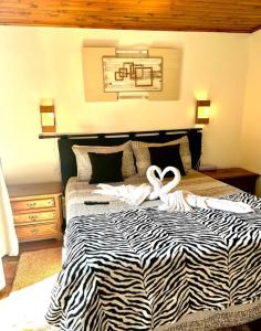 a bed with a black and white comforter with two white ribbon at Casa do Papai in Campos do Jordão