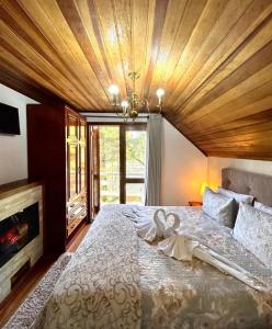 1 dormitorio con 1 cama grande y techo de madera en Casa do Papai, en Campos do Jordão