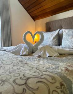 two swansrendered to look like hearts sitting on a bed at Casa do Papai in Campos do Jordão