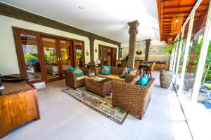 una sala de estar con sillas y mesas de mimbre en Villa CONOR - LEGIAN - SEMINYAK - 2 Bedroom 2 Bathroom Villa - Great Location, en Seminyak
