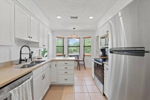 a kitchen with white cabinets and a sink at Spacious Home Near Beach, Large Yard, Game Room and Dog Friendly in Jacksonville