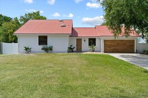 uma casa branca com um telhado vermelho e um quintal em Spacious Home Near Beach, Large Yard, Game Room and Dog Friendly em Jacksonville