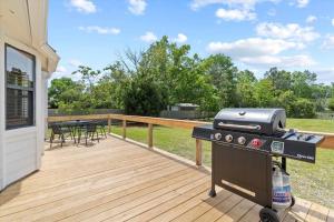 a grill on a deck with a table and chairs at Spacious Home Near Beach, Large Yard, Game Room and Dog Friendly in Jacksonville
