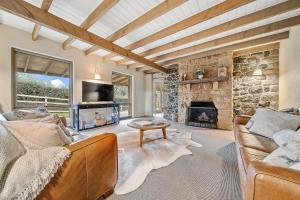 a living room with a couch and a fireplace at Quigtoo Cottage in Berridale
