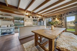 a kitchen with a wooden table in a room at Quigtoo Cottage - Beautiful 4BR Stone Cottage l WiFi l Bath l Garden in Berridale