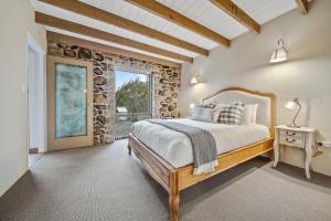 a bedroom with a bed and a stone wall at Quigtoo Cottage in Berridale