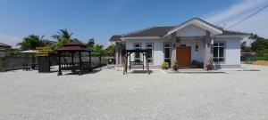 a small house with a playground in front of it at Homestay Restu Mak Abah Private Pool Melaka in Merlimau