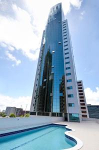 a tall building with a swimming pool in front of it at BEIRA MAR- FLAT EXECUTIVE in Recife