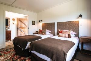 Habitación de hotel con 2 camas y pasillo en The Winemaker's Cottage - Coast & Country, en Omiha