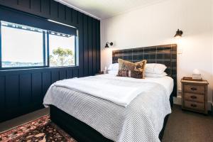 Un dormitorio con una cama grande y una ventana en The Winemaker's Cottage - Coast & Country, en Omiha